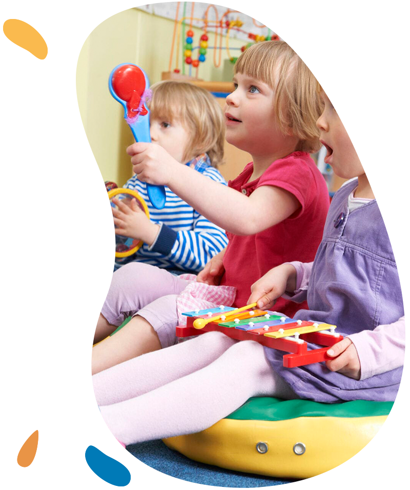 Group Of Pre School Children Taking Part In Music Lesson